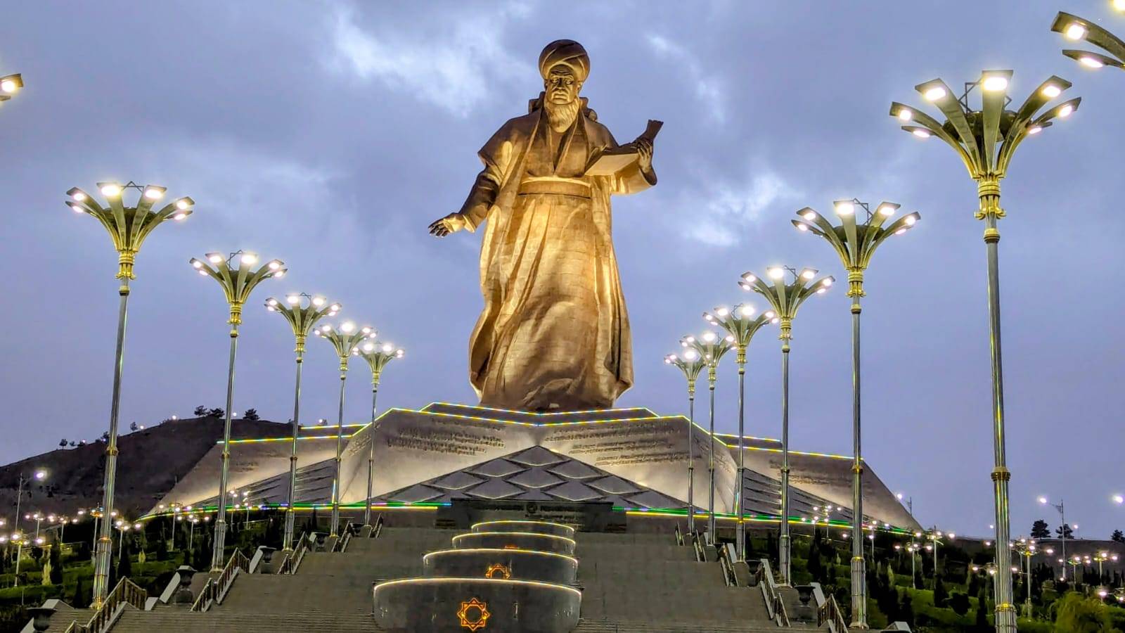 4 Day Turkmenistan Tour: Farab to Shavat via Merv, Ashgabat & Darvaza Monument to famous Turkmen poet Magtymguly Pyragy illuminated at dusk in Ashgabat, Turkmenistan