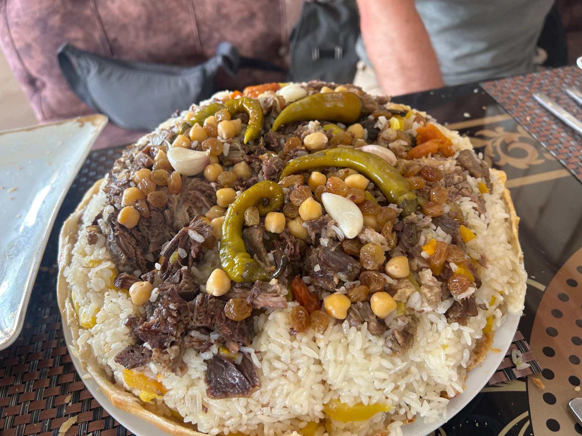 3 Day Turkmenistan Tour from Ashgabat: Darvaza & Night Train to Bukhara Traditional Turkmen Han Plov served with rice, tender meat, chickpeas, raisins, garlic and peppers at a restaurant in Ashgabat