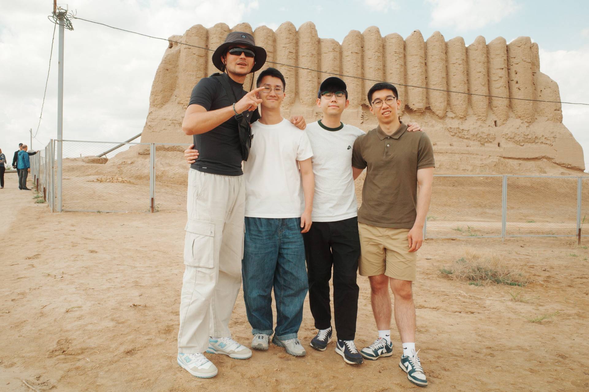 2 Day Turkmenistan Tour from Bukhara: Merv & Ashgabat Darvaza Tour guide Mekan with three travelers from Hong Kong in front of the Kyz Kala ruins at Ancient Merv, Turkmenistan