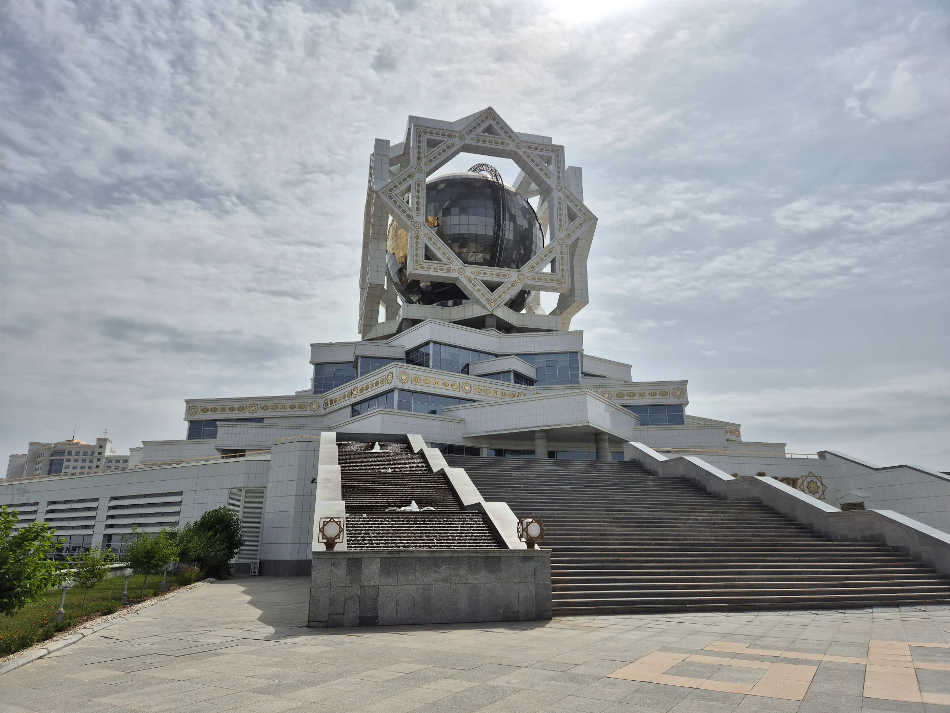 2 Day Turkmenistan Tour from Bukhara: Merv & Ashgabat Ashgabat Wedding Palace in daylight featuring its monumental star-shaped structure, mirrored sphere and broad staircase