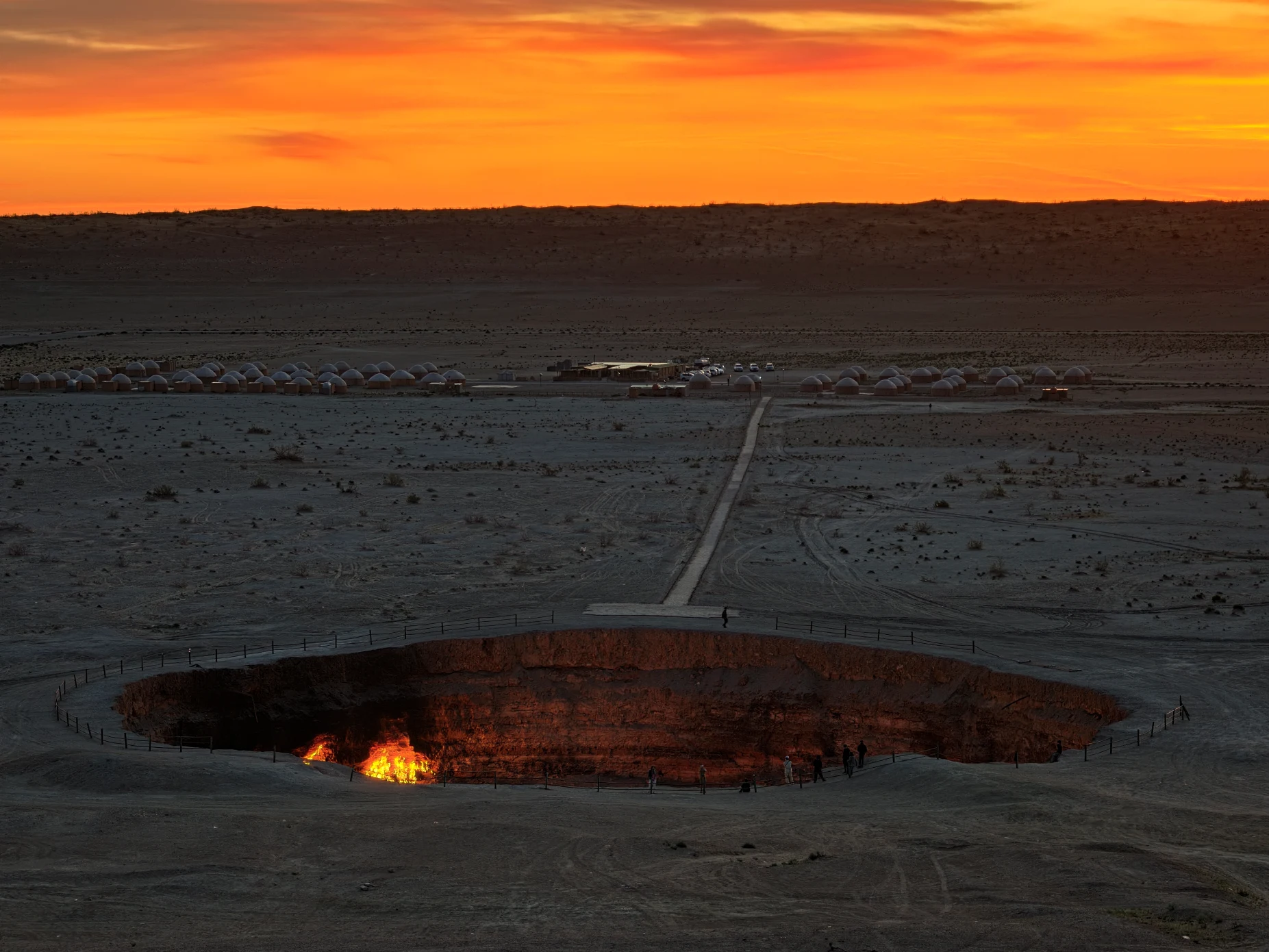 5 Day Turkmenistan Tour from Khiva: Darvaza, Ashgabat & Merv Darvaza Gas Crater glowing at sunrise with tourists and a traditional yurt camp in the Karakum Desert, Turkmenistan