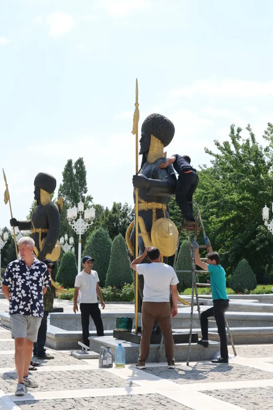 2 Day Turkmenistan Tour from Bukhara: Merv & Ashgabat Traditional Turkmen warrior statues with shields and spears being maintained near a monument complex in Ashgabat, Turkmenistan