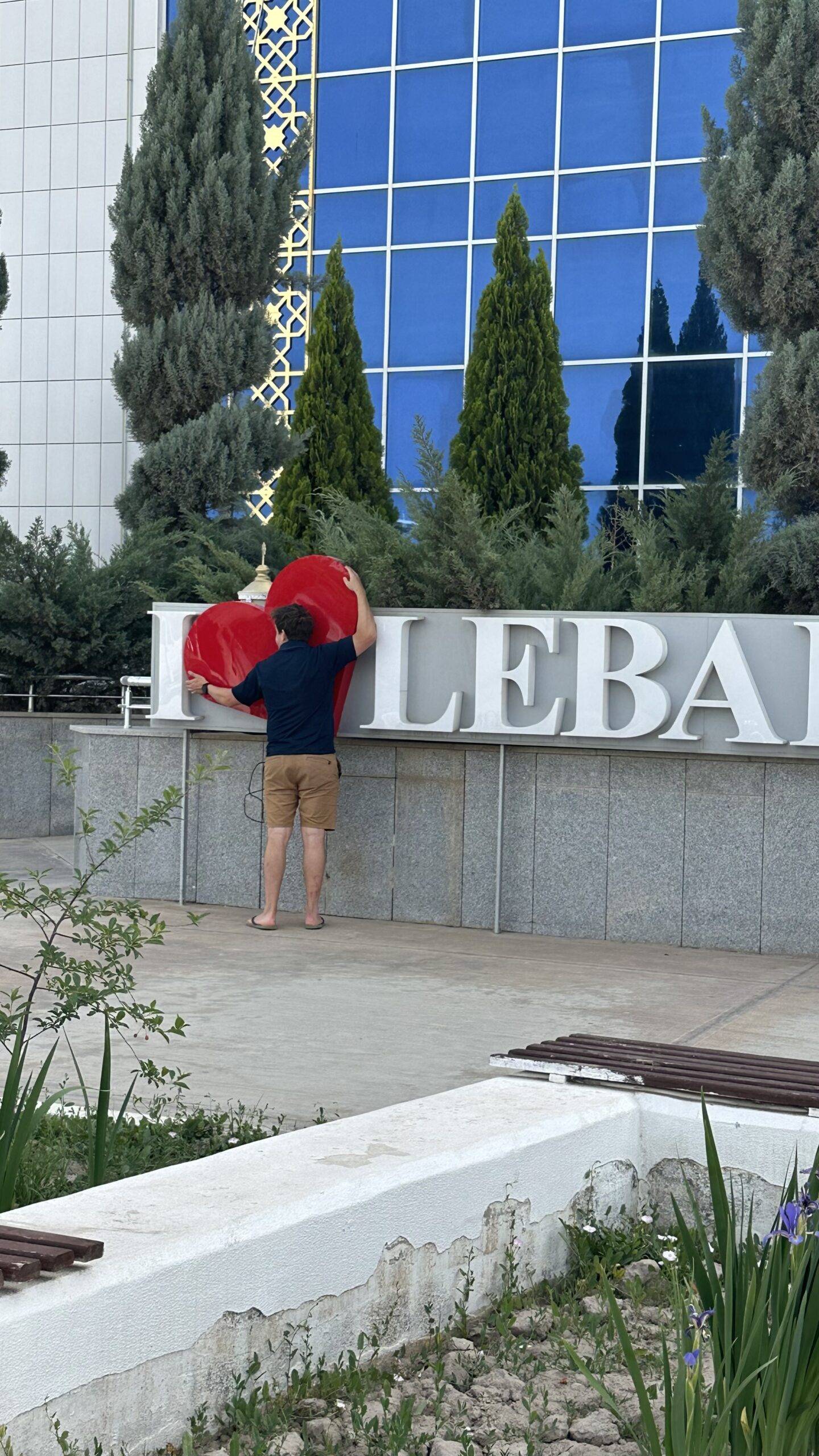 3 Day Turkmenistan Tour from Ashgabat: Darvaza & Night Train to Bukhara Traveler hugging the red heart of the I Love Lebap sign outside Lebap Shopping Center in Turkmenabat