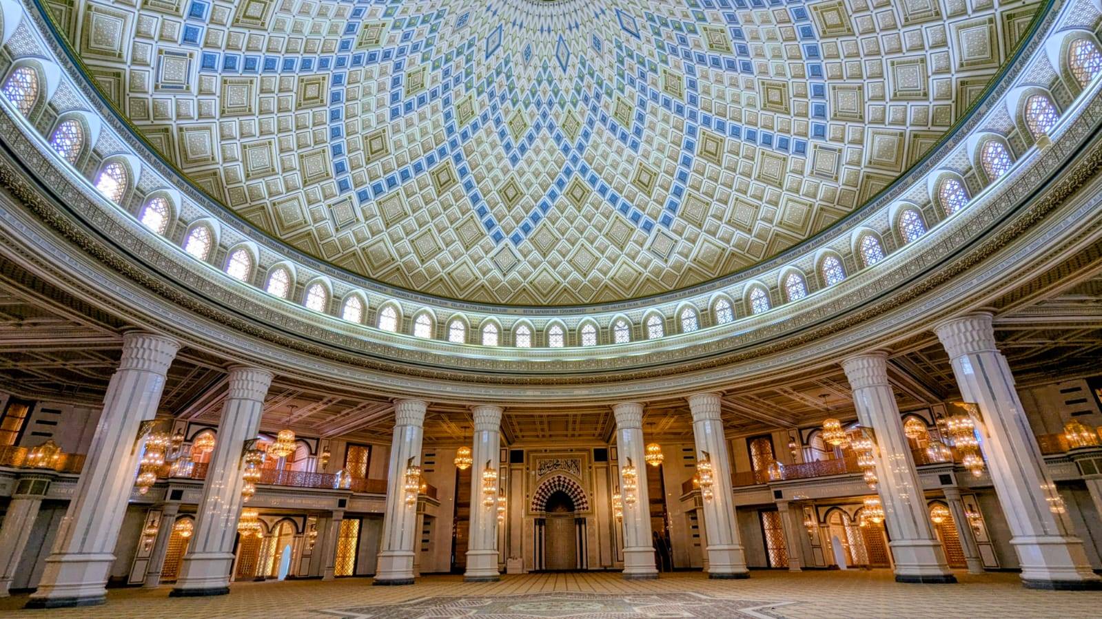 4 Day Turkmenistan Tour: Farab to Shavat via Merv, Ashgabat & Darvaza Grand interior of Turkmenbashi Ruhy Mosque with decorated dome, white columns and chandeliers in Turkmenistan