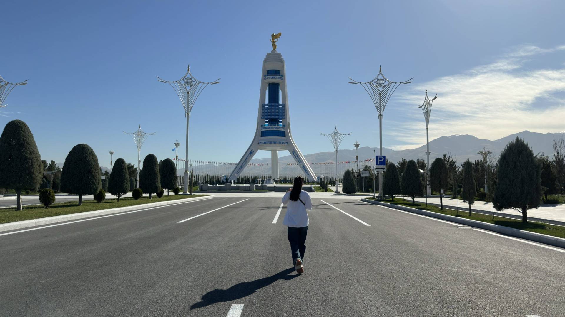 4 Day Turkmenistan Tour: Farab to Shavat via Merv, Ashgabat & Darvaza Local guide Aiza walking toward the Monument of Neutrality during an Ashgabat city tour in Turkmenistan