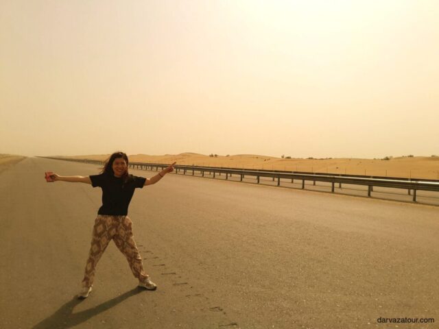 Traveler enjoying the scenic highway between Turkmenabat and Mary in Turkmenistan - expansive desert landscape with endless road stretching into the horizon during golden hour on Japan Samurai Tour