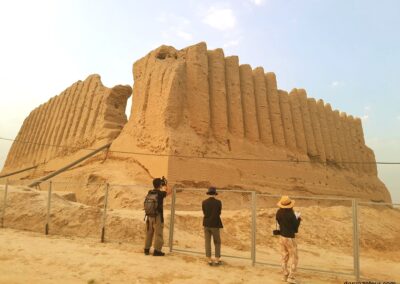 Ancient fortress ruins in Karakum Desert, Turkmenistan - historical mud brick citadel against golden sunset sky during desert tour