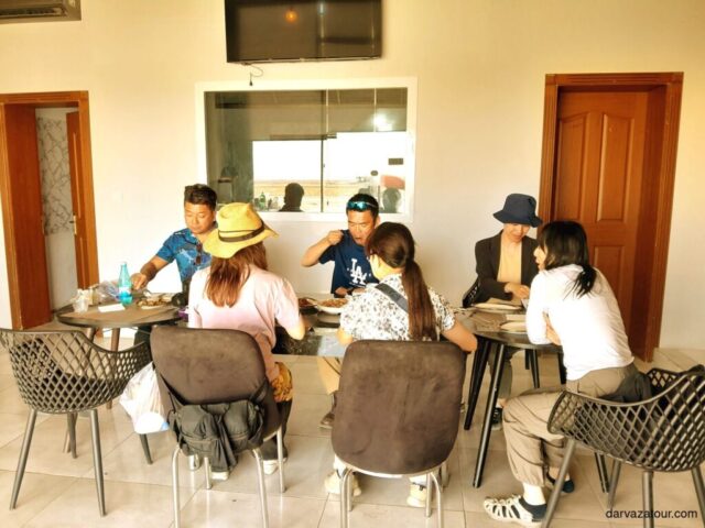 Tourists enjoying authentic Turkmen cuisine including Gowurma and Palaw during a travel stop in Turkmenistan. Local dining experience in Ashgabat region featuring national dishes of Turkmenistan.