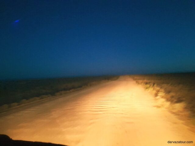 Evening drive on Turkmenistan highway to Turkmenbashi city with golden sunset illuminating the desert road