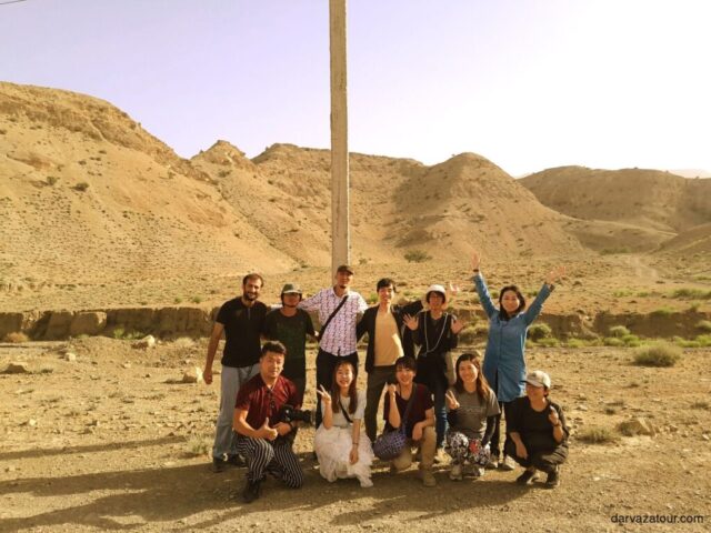 A tourist meeting Japanese travelers while descending from the mountain, enjoying the picturesque landscape and cultural exchange during a tour of Turkmenistan.