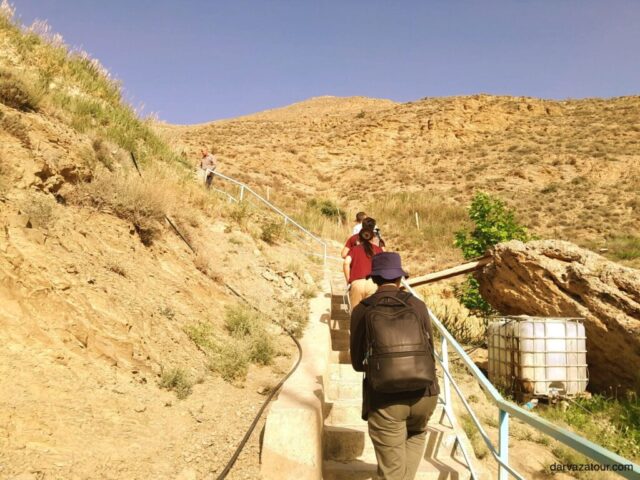 Tourists ascending stone pathway to historic Gyz Bibi Mausoleum in Turkmenistan desert landscape - authentic Central Asia travel experience at ancient historical site near Ashgabat - Turkmenistan tour highlights 2025