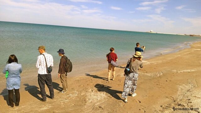 Visitors walking along the sandy beach of Avaza on the Caspian Sea coast during Turkmenistan tour