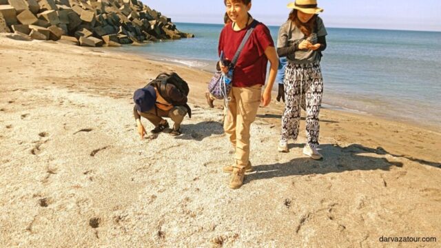 Tourists walking along the sandy shores of Avaza resort on the Caspian Sea coastline in Turkmenistan. Popular tourist destination showcasing Turkmenistan's beautiful beaches and natural landscapes.