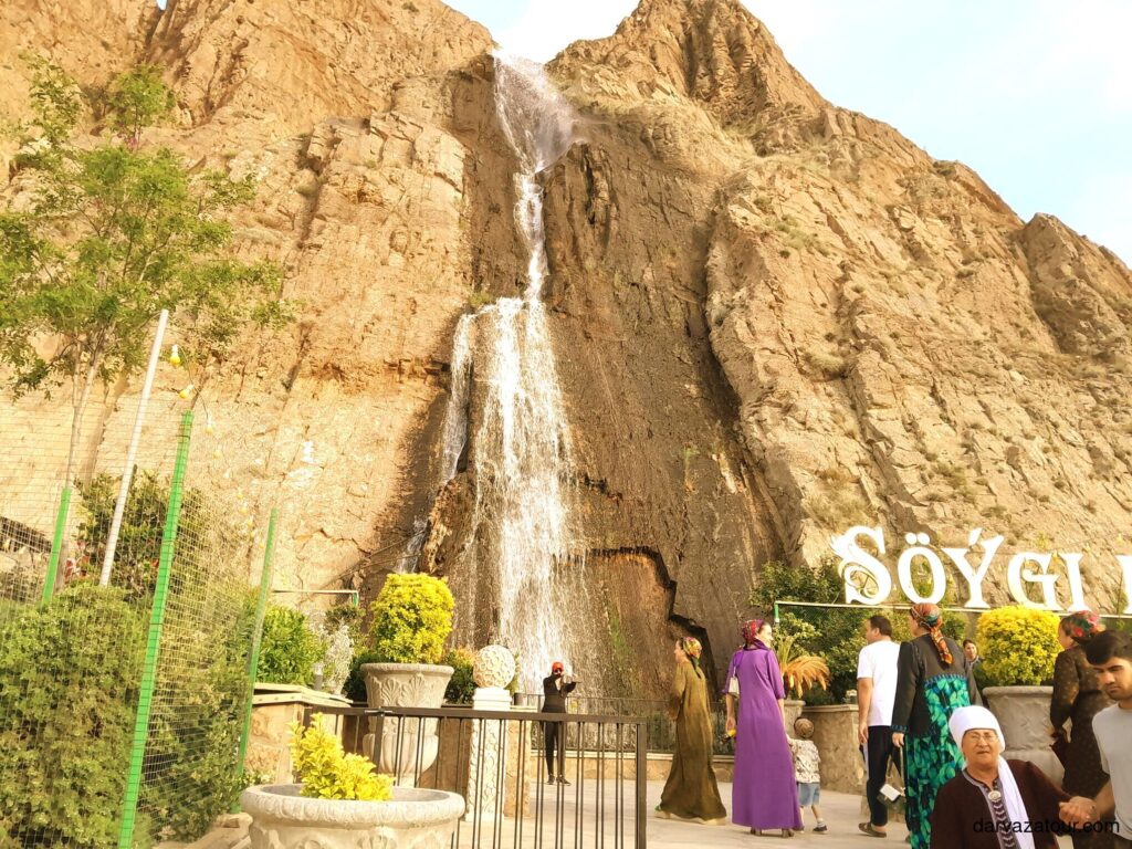 Visitors walking near the waterfall in Nokhur village, Turkmenistan, at the foot of the so-called "Mountains of Love".