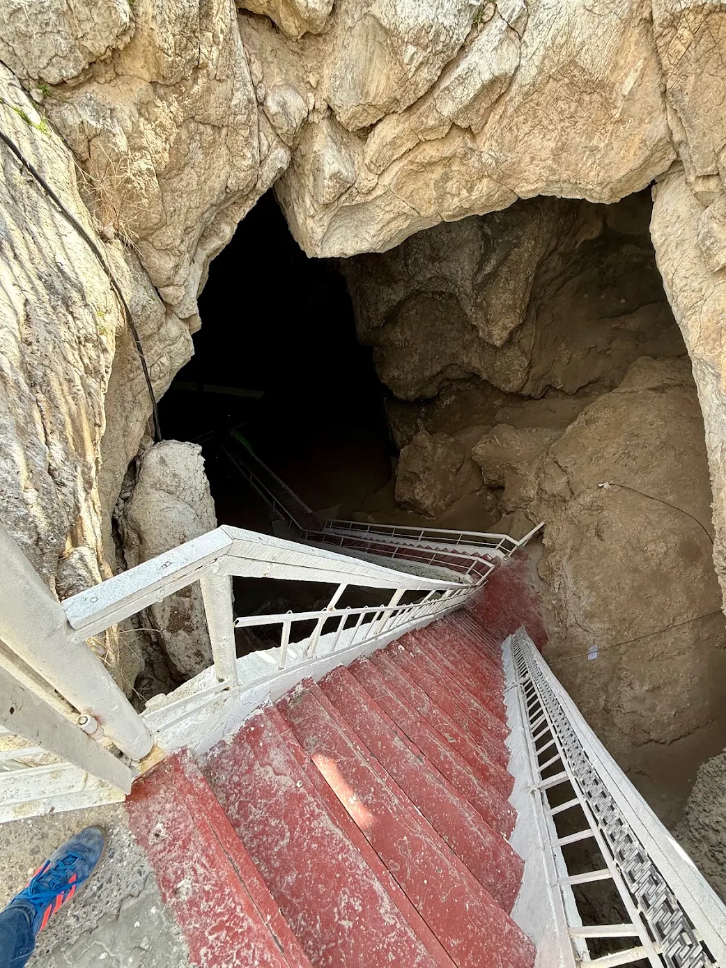 Entrance to Kow-Ata Underground Lake Rocky entrance and steep staircase leading into Kow-Ata Cave and its underground thermal lake in Turkmenistan