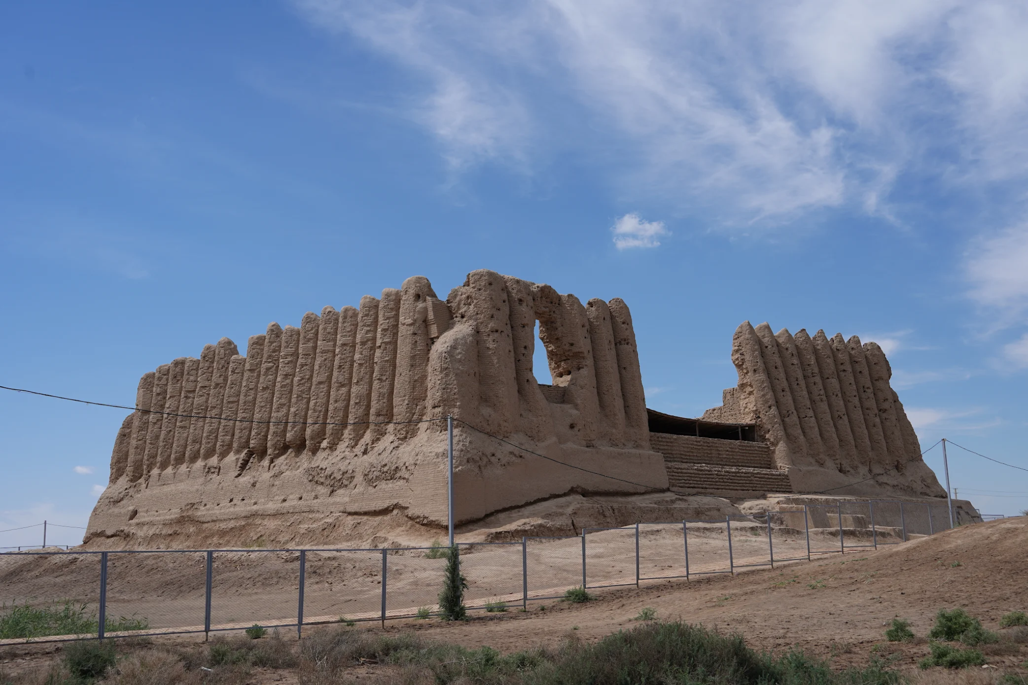 Historic Kyz Kala ruins surrounded by desert vegetation at the Ancient Merv archaeological site in Turkmenistan