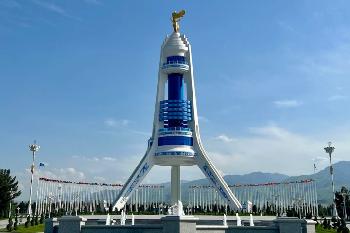 Monument of Neutrality in Ashgabat with the golden statue of Saparmurat Niyazov rising above fountains and landscaped grounds