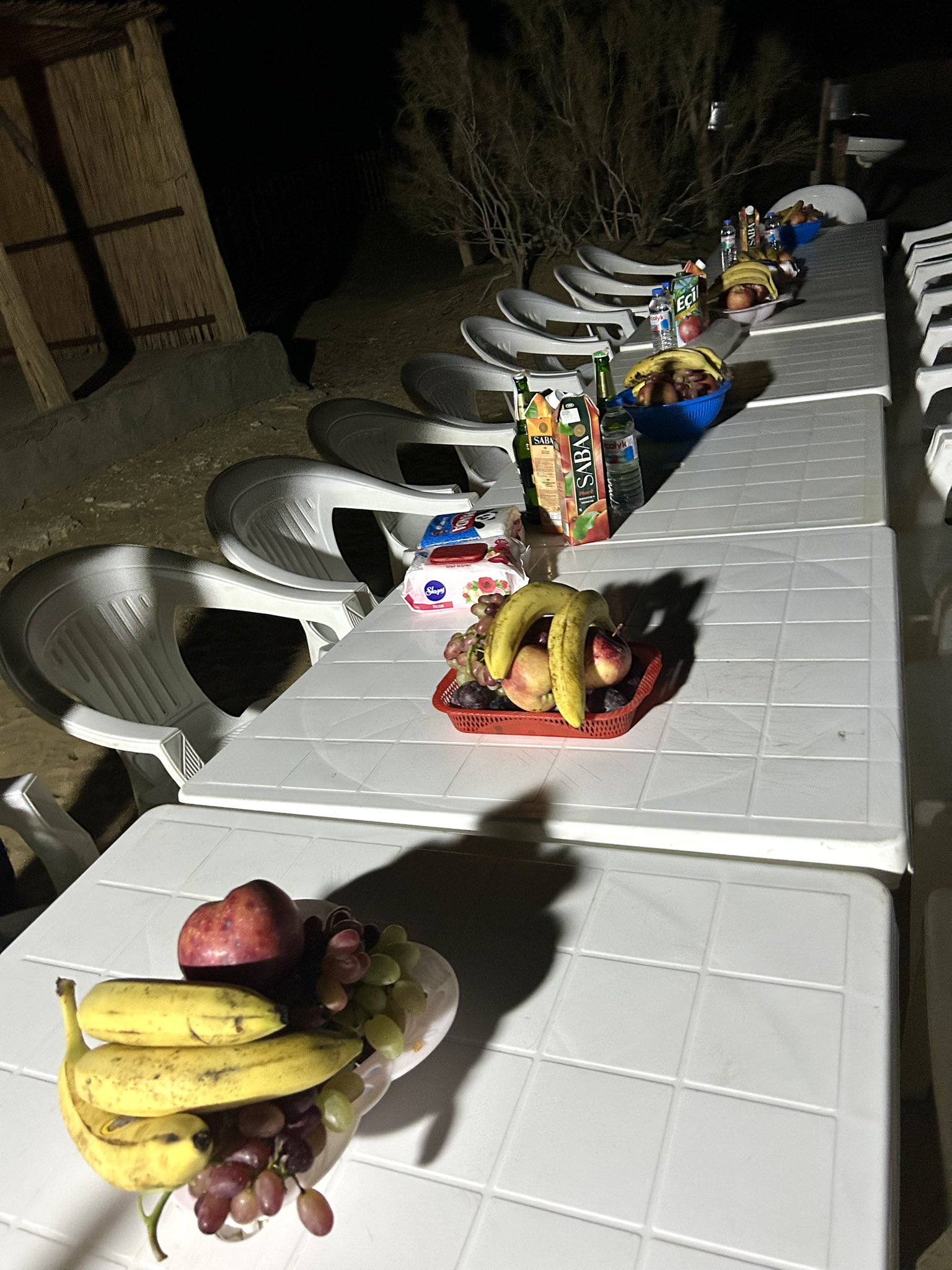 This photo was taken at the Darvaza Gas Crater Yurt Camp. The table was prepared for about eight people, but the shashlik and salads had not arrived yet. Only fruits and drinks were placed on the table for now. Later the shashlik, salads, and cakes for each person would arrive, because after dinner everyone wants to eat something sweet.