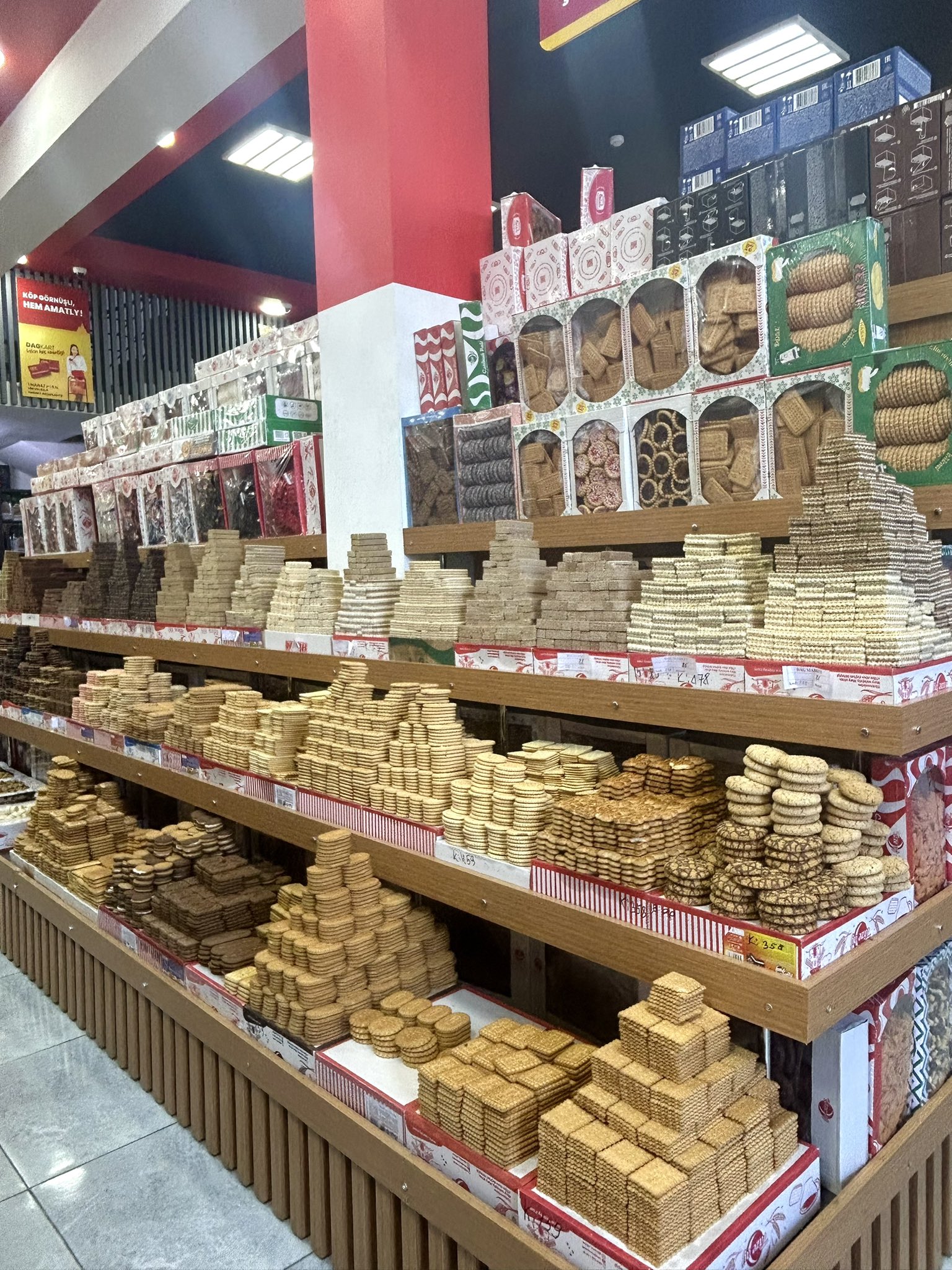 This photo was taken in a supermarket in Ashgabat. They built tall pyramid-shaped displays made only from cookies, with many types of wafers and sweets stacked like stairs. The cookie pyramid in the middle does not move at all and looks perfect. I think this cookie is called Hazar, because I remember eating it when I was a child and it was very tasty.