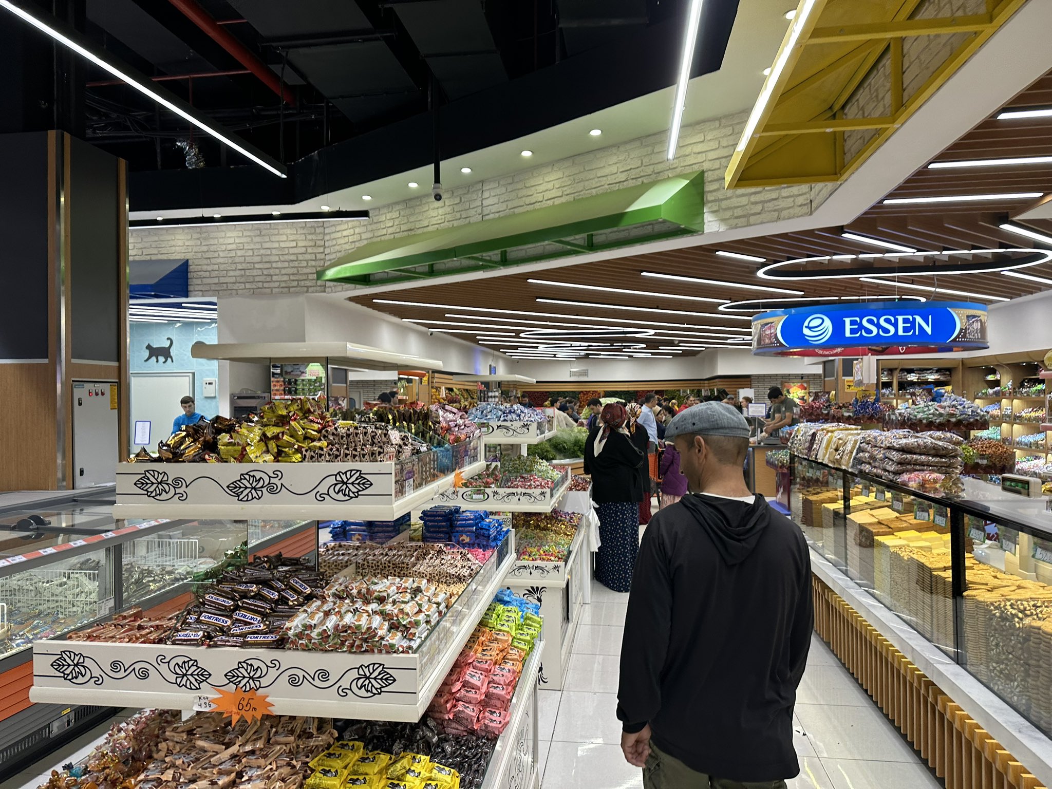 Tourist exploring a supermarket in Ashgabat, browsing local products and watching residents shop.