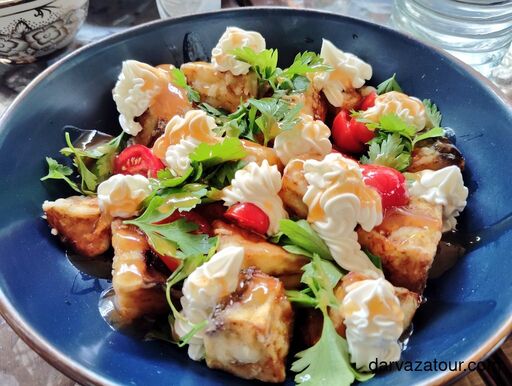 Cheese pide served on a wooden tray in Ashgabat restaurant, enjoyed by tourists.