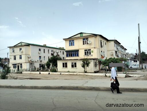 Schoolboy walking home in Turkmenistan with Soviet-era apartment buildings in the background