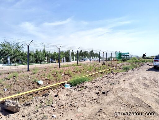 Uzbekistan–Turkmenistan border fence near Farab crossing point, with gas pipeline and desert landscape