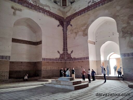 White marble buildings and tree-lined avenue in Ashgabat, Turkmenistan, at sunset.
