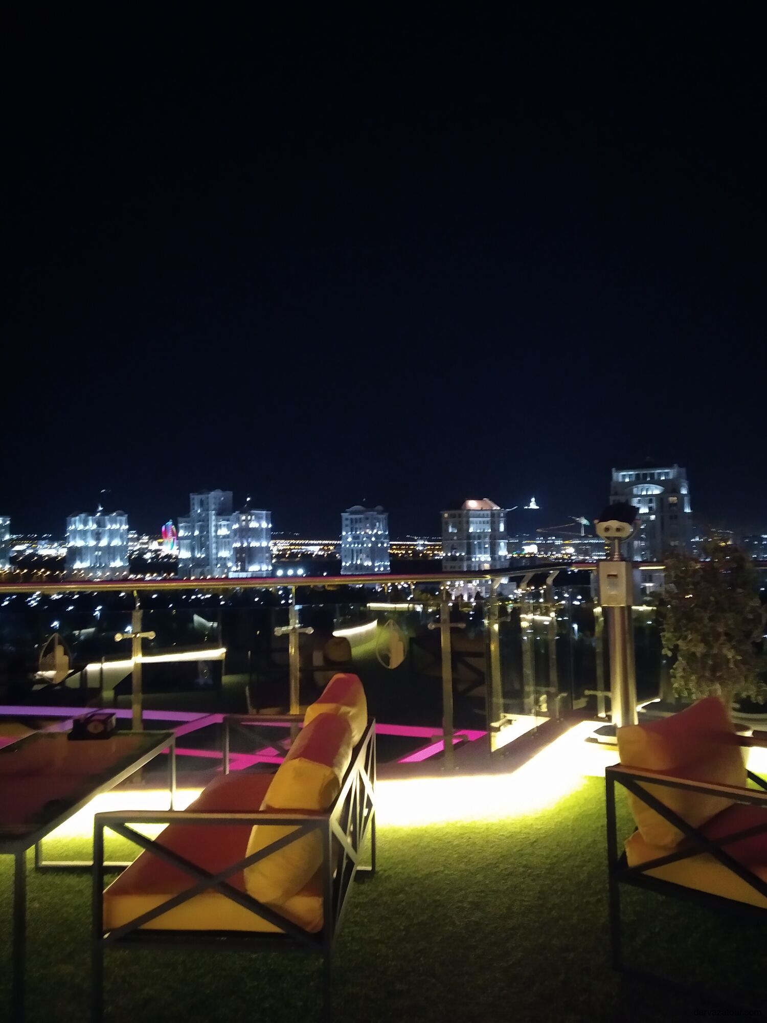 Night view of Ashgabat city from rooftop terrace with glowing lights and modern skyline
