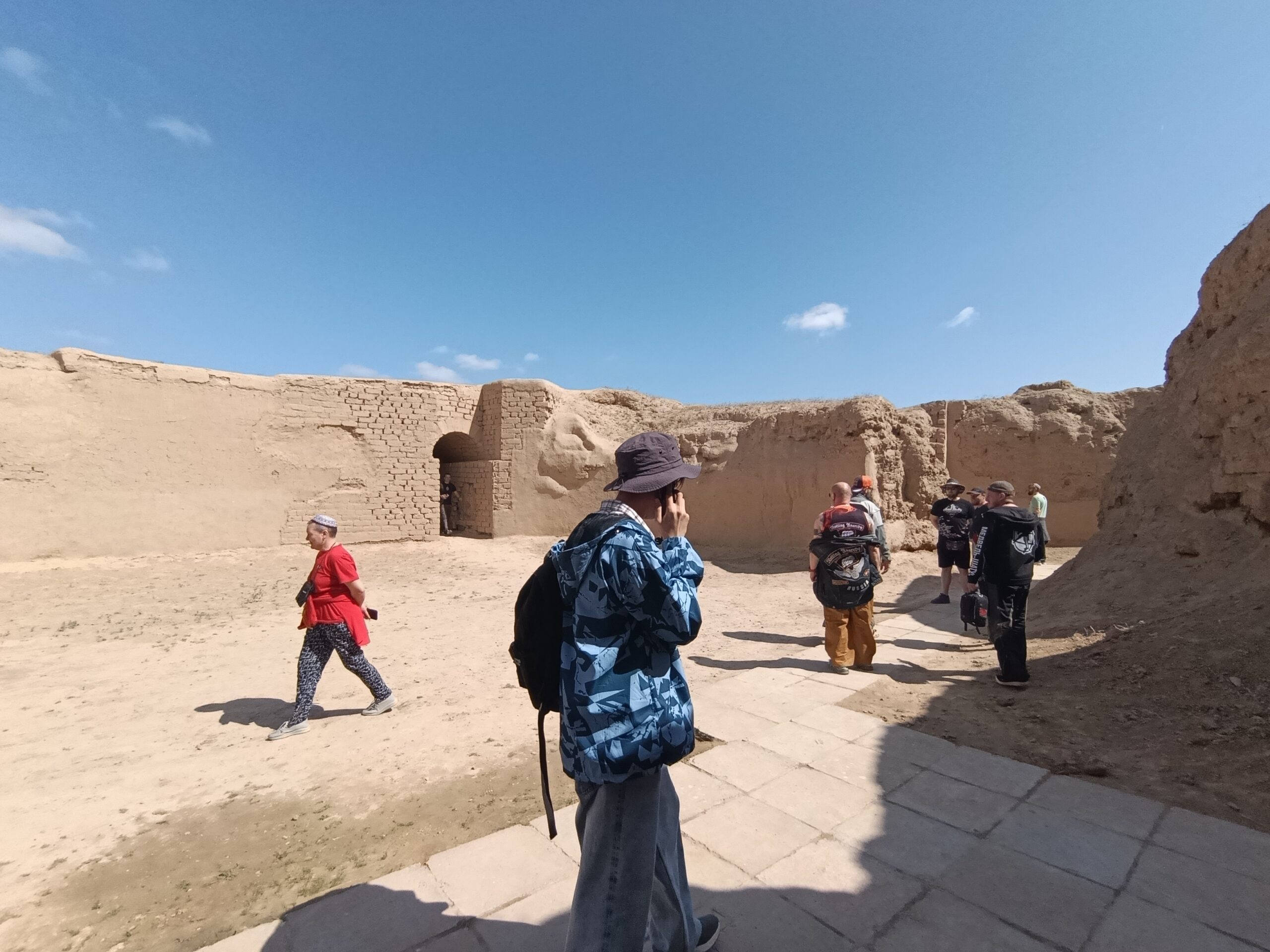 Tourists exploring the mud-brick ruins and archaeological remains of Ancient Nisa in Turkmenistan