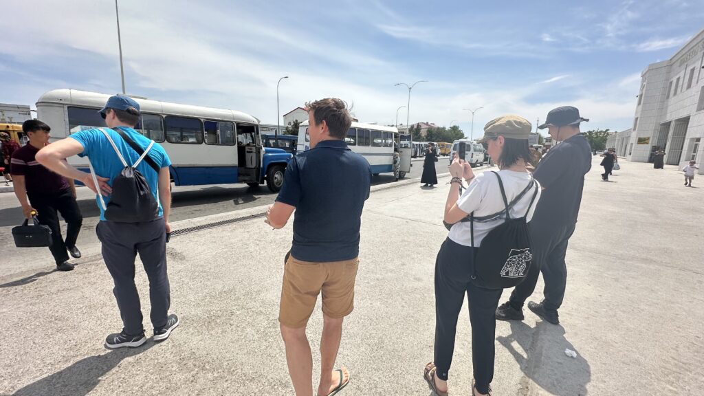 Travelers discovering local buses near Gok Bazaar during their Turkmenabat city tour