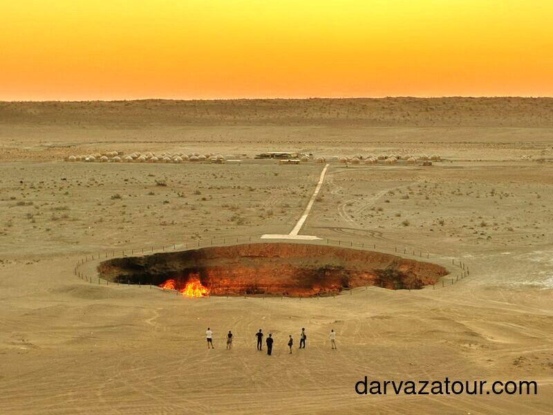 Tourist group in Japan exploring the famous Darvaza Gas Crater in Turkmenistan travelers experiencing the burning natural gas crater known as the Gates of Hell during guided tour