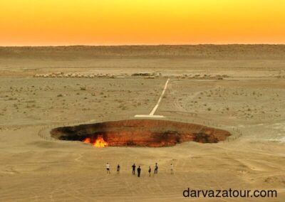 Panoramic view of the Darvaza Gas Crater at sunrise, showcasing the desert landscape of Turkmenistan.