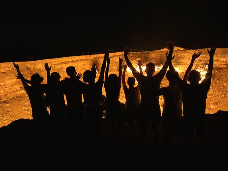 Tourist group in Japan exploring the famous Darvaza Gas Crater in Turkmenistan<br />
travelers experiencing the burning natural gas crater known as the Gates of Hell during guided tour