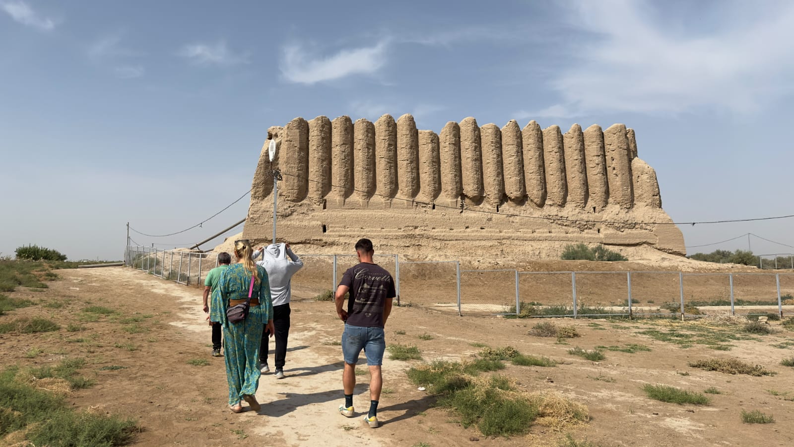 Travellers walking towards the corrugated mud-brick walls of Great Kyz Kala at Ancient Merv