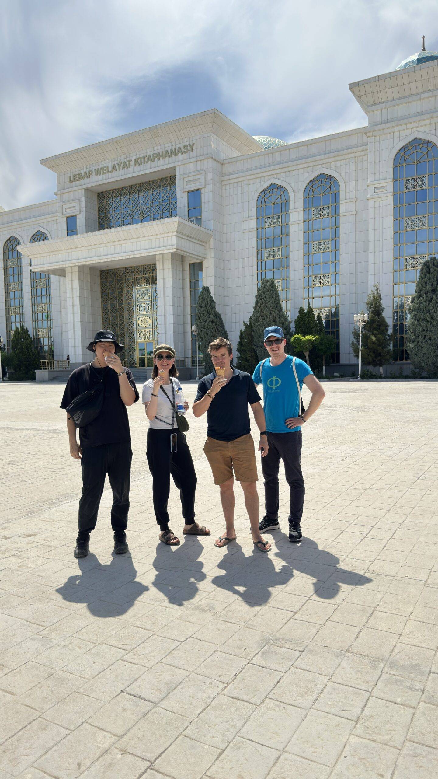International travelers enjoying ice cream outside Lebap Regional Library during a Turkmenabat city tour in Turkmenistan
