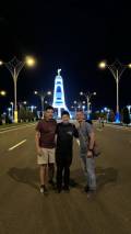Malaysian Travelers at the Monument of Neutrality at Night