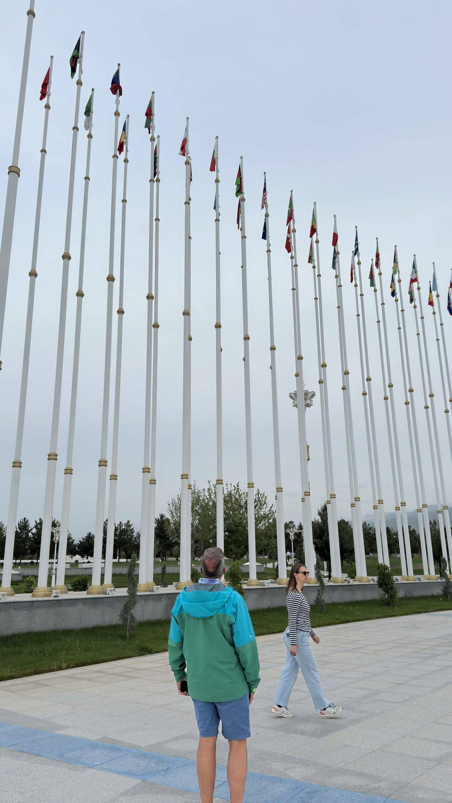 American tourists exploring the international flag display at the Independence Monument in Ashgabat
