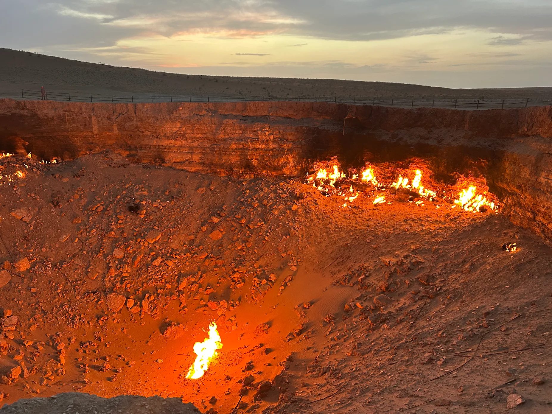 Natural gas flames burning inside the Darvaza Gas Crater in the Karakum Desert of Turkmenistan as evening approaches