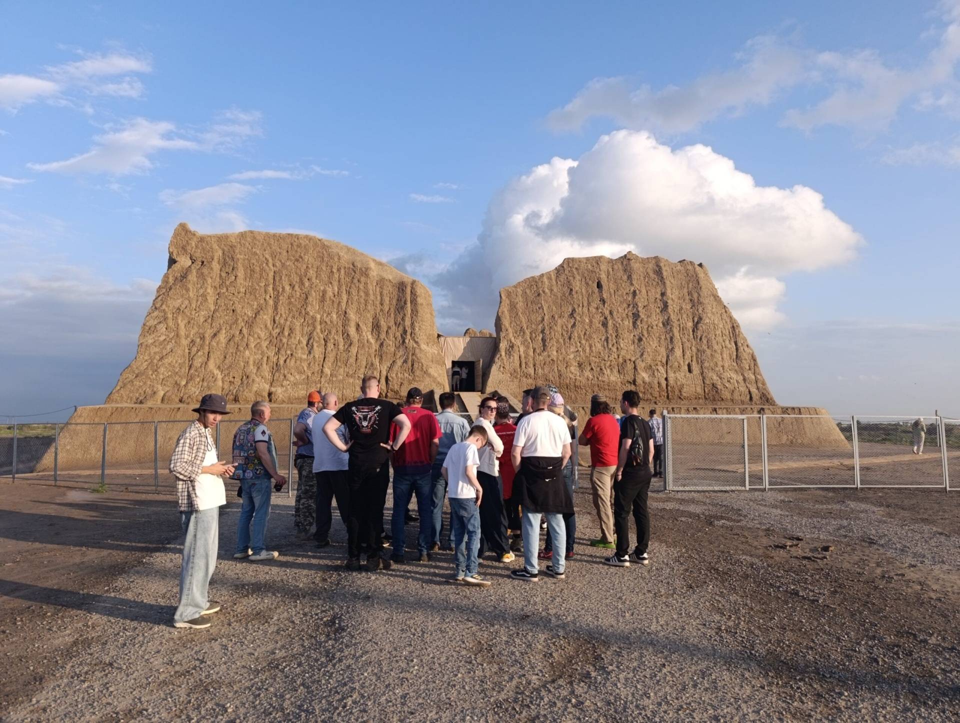 Tourists preparing to explore the monumental mud-brick walls of Great Kyz Kala at Ancient Merv