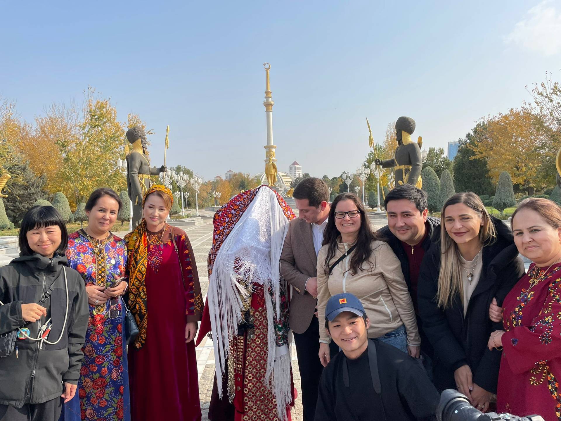 International tourists meeting a Turkmen wedding party in traditional clothing during their Ashgabat city tour
