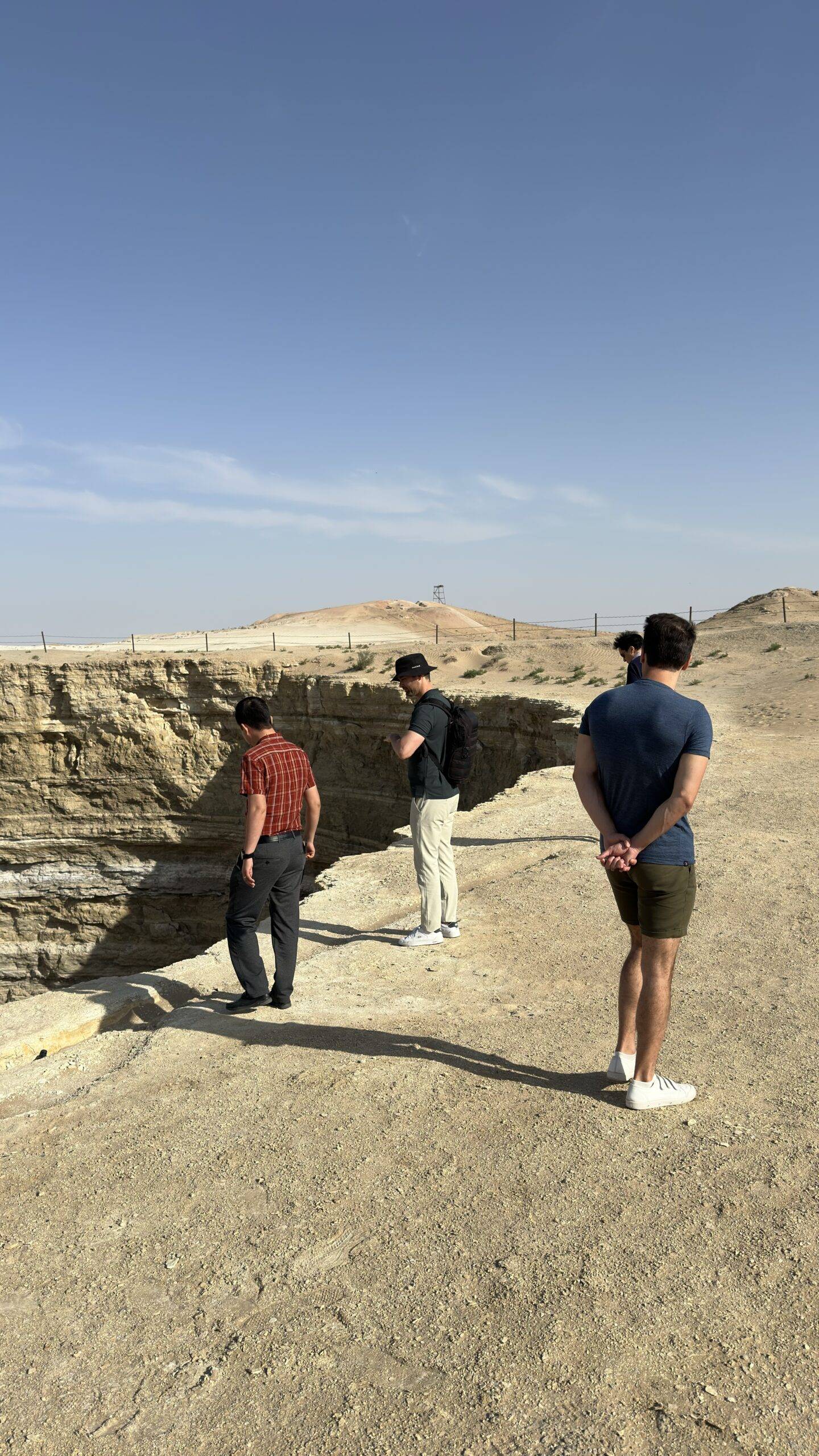French tourists and other travelers exploring the Mud Crater near Darvaza in the Karakum Desert, Turkmenistan