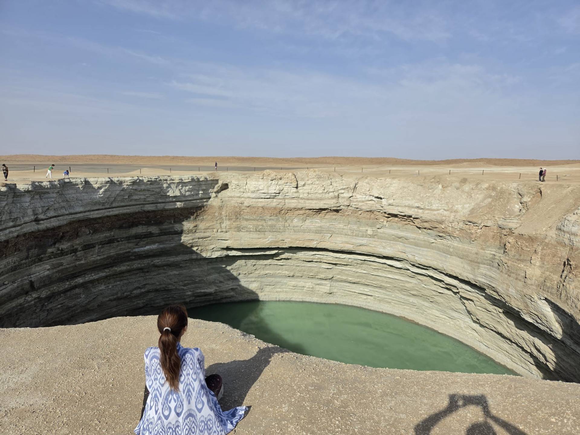 Chinese tourist enjoying the view of the Water Crater near Darvaza in the Karakum Desert, Turkmenistan